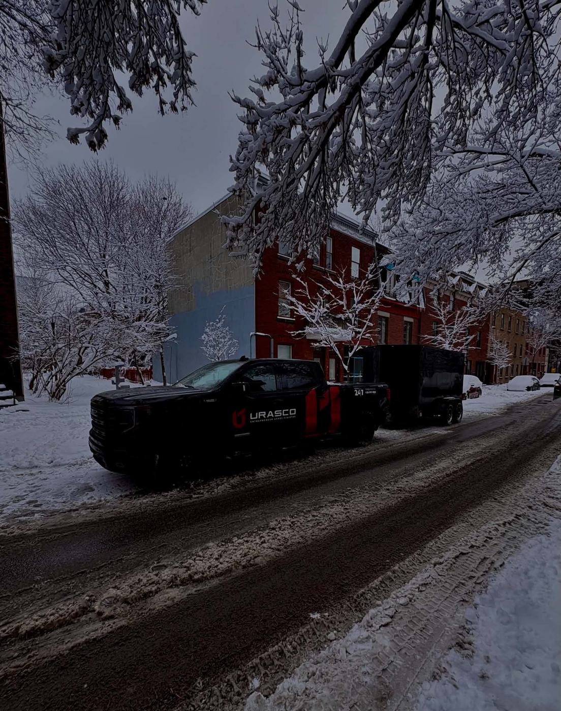 Camion et remorque Urasco dans une rue enneigée